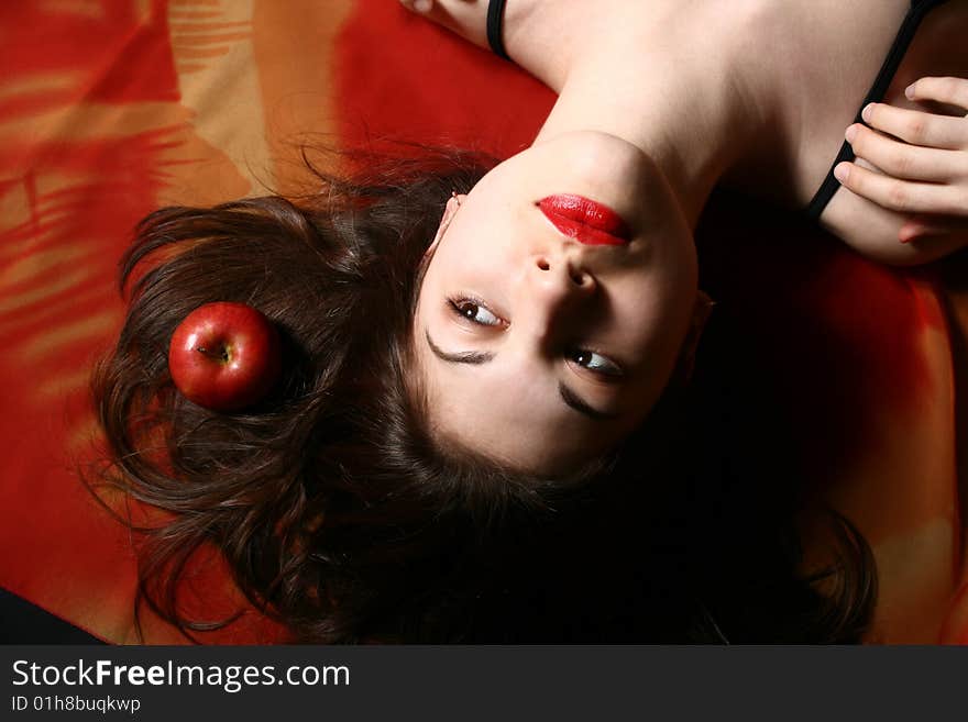 Portrait of the beautiful girl with an apple and developing hair. Portrait of the beautiful girl with an apple and developing hair.