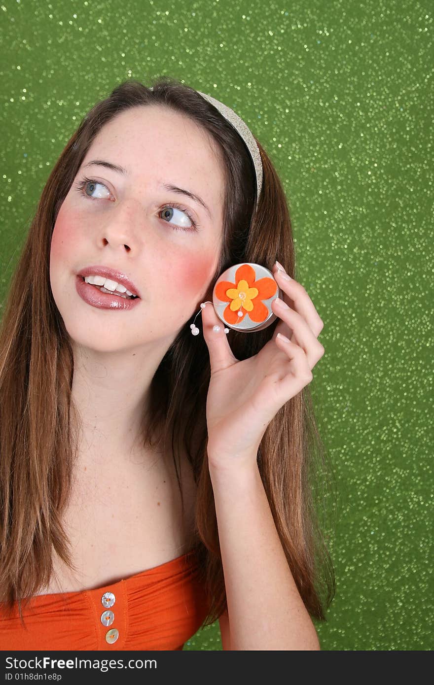 Brunette teenager on a green background wearing a broad head band. Brunette teenager on a green background wearing a broad head band