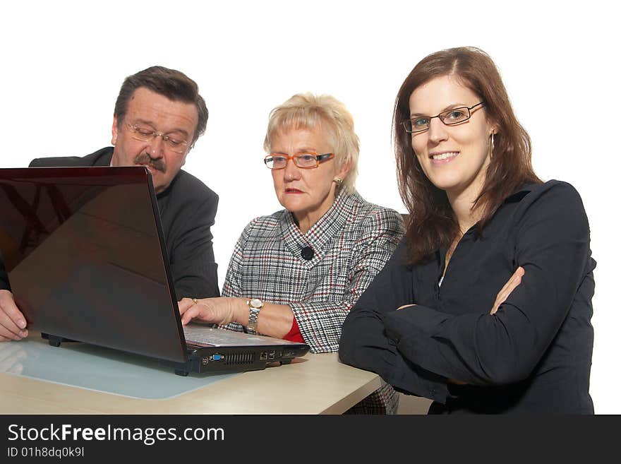 A business team of three sitting in front of a laptop. Focus is on the young woman in front. Isolated over white. A business team of three sitting in front of a laptop. Focus is on the young woman in front. Isolated over white.