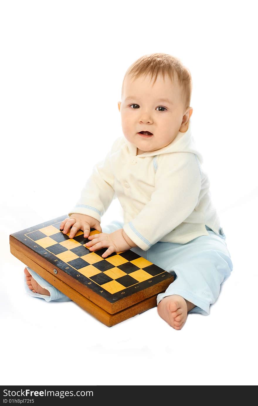 Cute ten months old baby sitting on the floor with a chessboard in his hands. Cute ten months old baby sitting on the floor with a chessboard in his hands