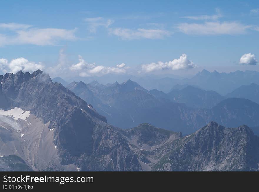 Alpine mountains landscape with haze and clouds. Alpine mountains landscape with haze and clouds