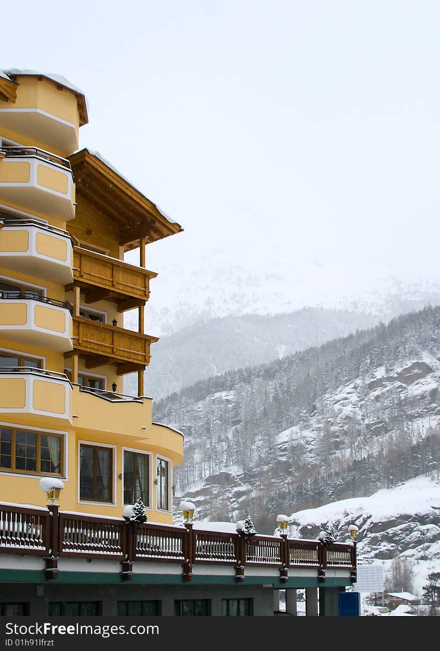 Hotel in Alps, mountain in fog at background