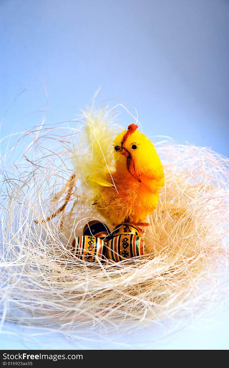 Easter background with decorative toys as a nest with a chicken and eggs