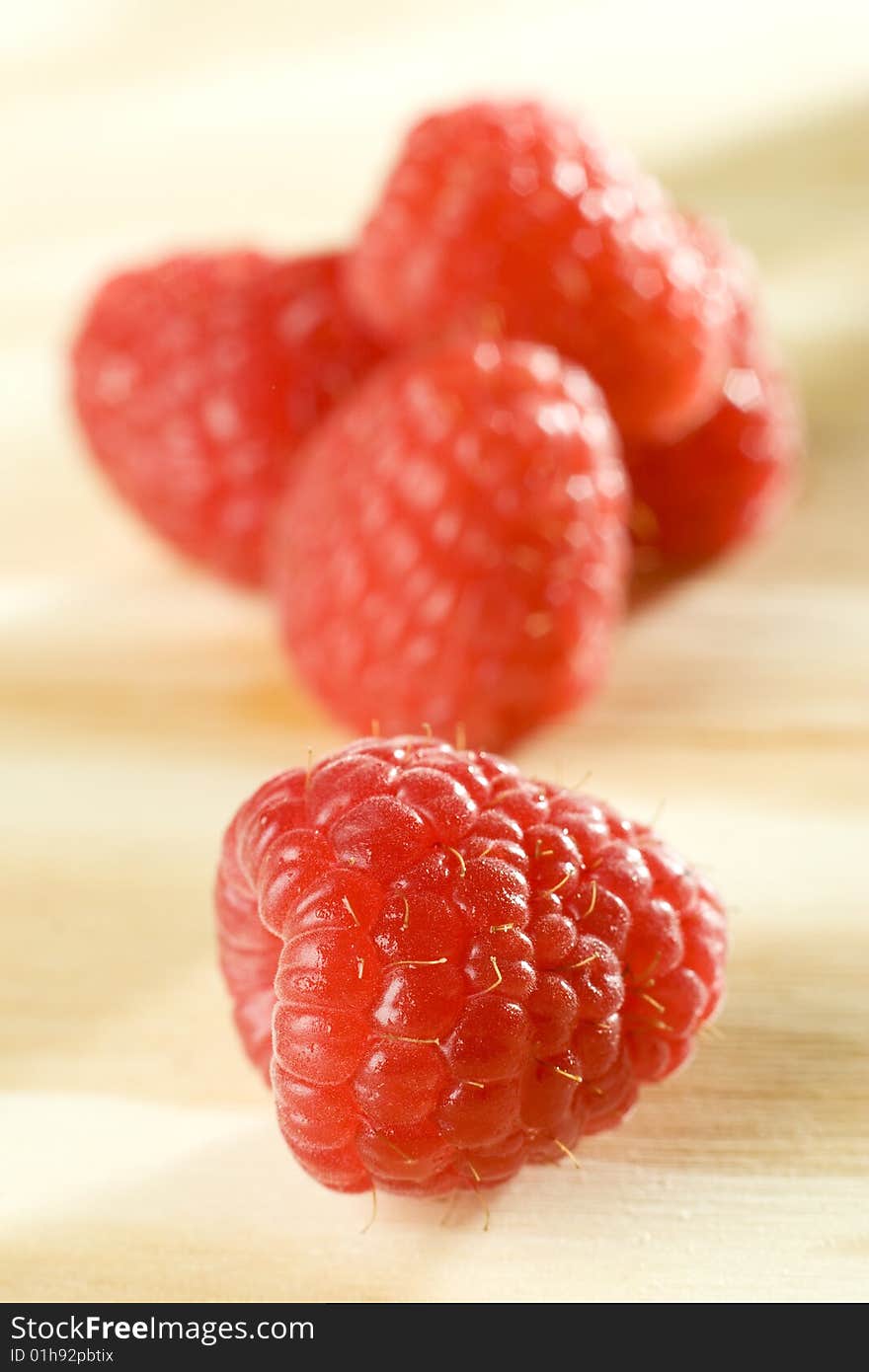 Close up shot of freshly picked raspberry on a wooden table top. Close up shot of freshly picked raspberry on a wooden table top