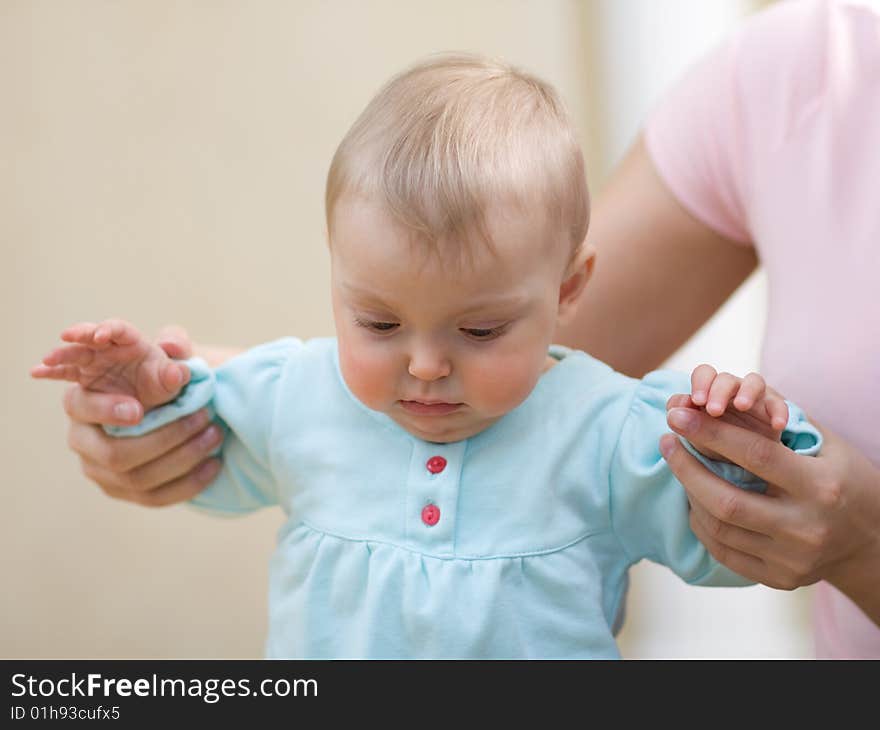 Baby making first steps with mom's help - shallow DOF