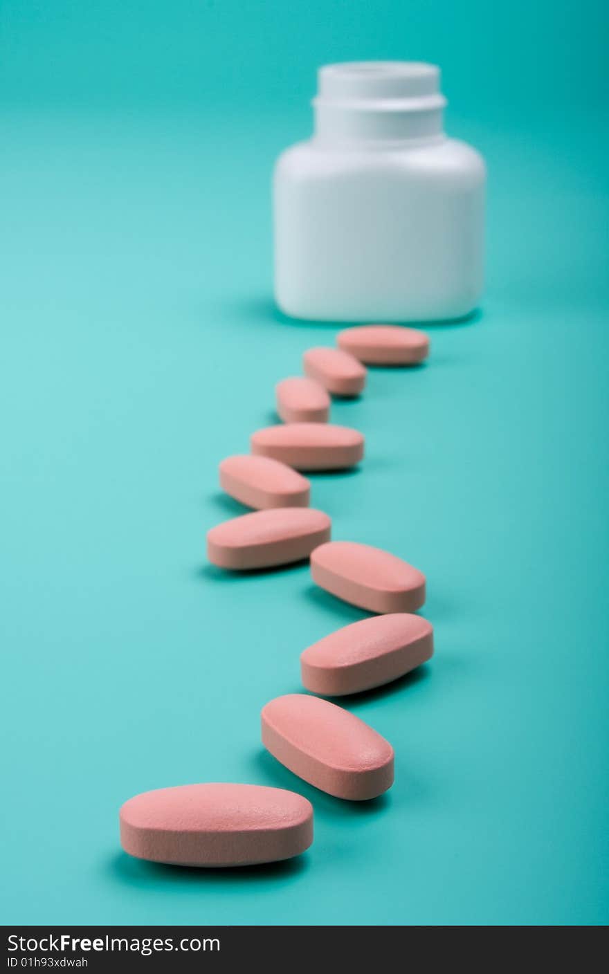 Pills path going from the bottle at the green background