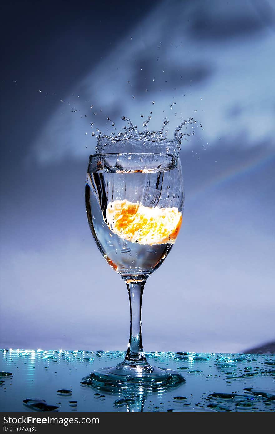 The glass with drinkable water and mandarin