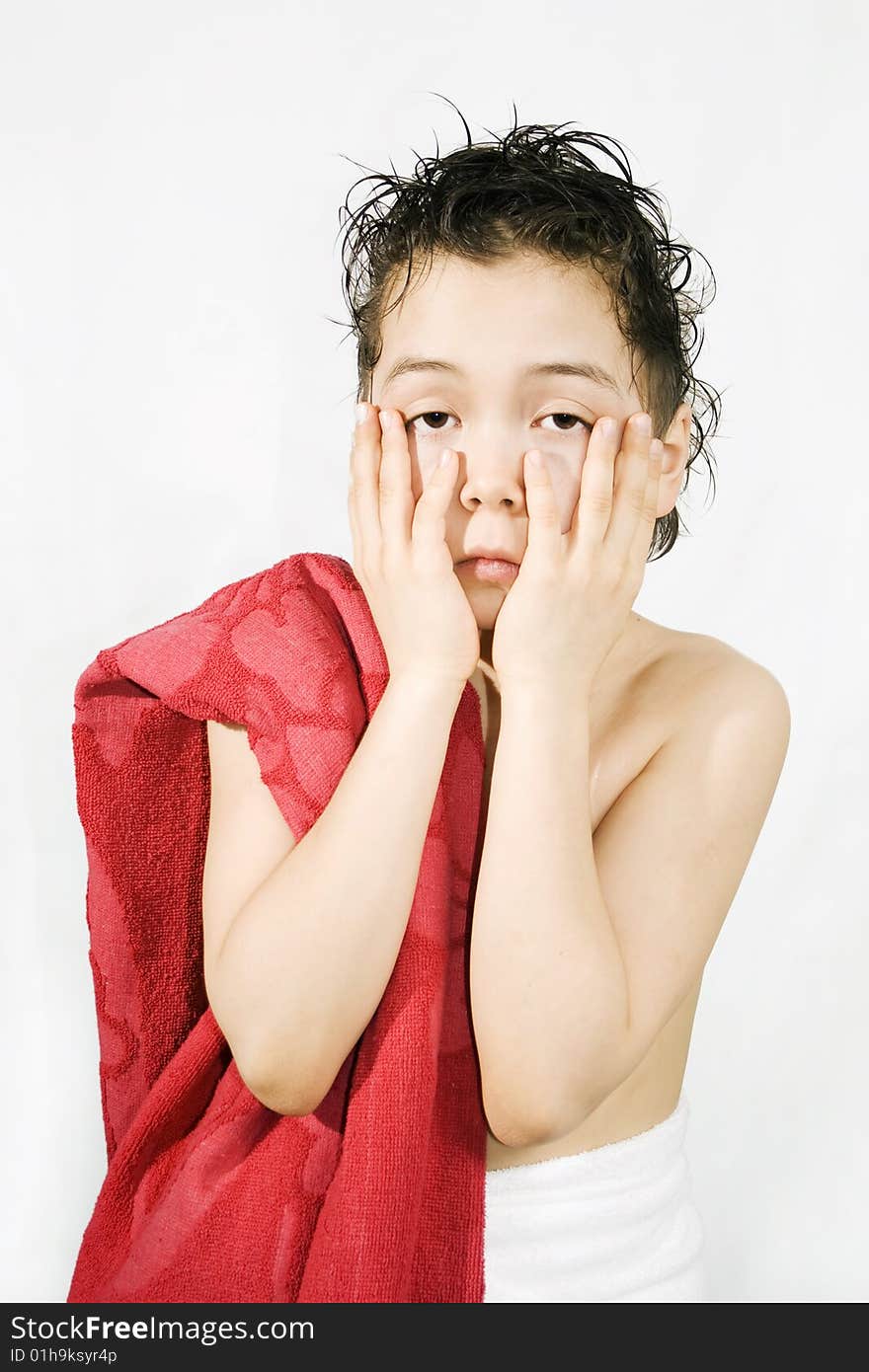 Sad boy with the red towel by hands holds face