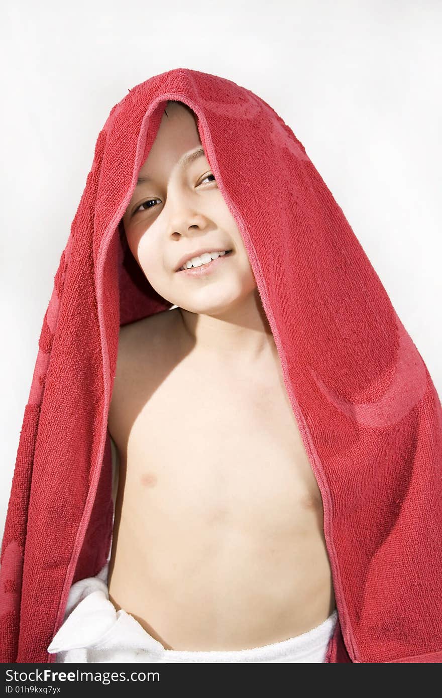 Cheerful boy with the red towel on its head