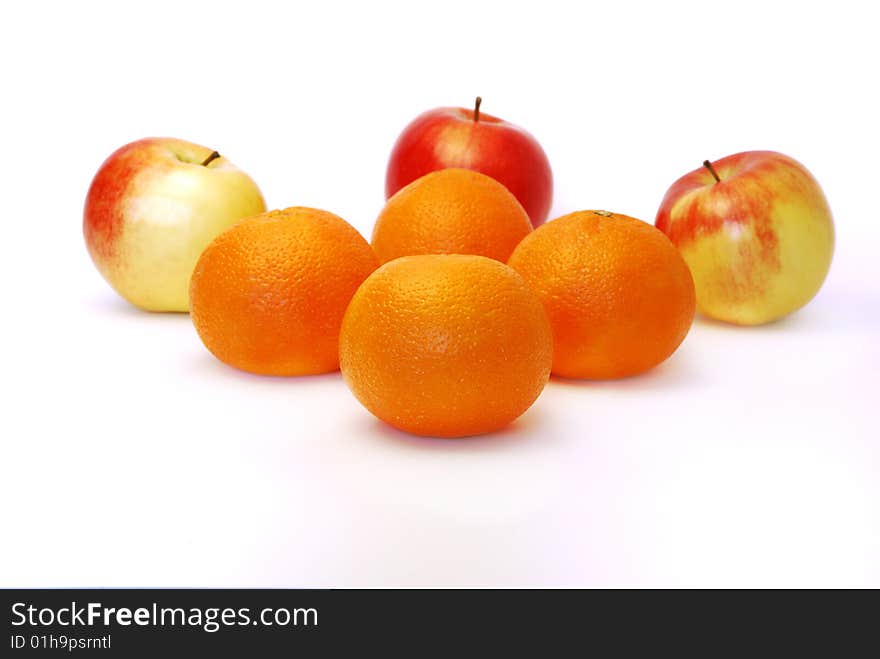 Four mandarines and three apples on a white background