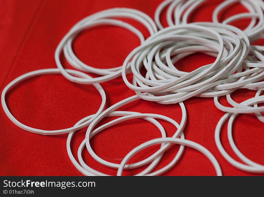 Some white elastic bands which used for magic show with a red background. Some white elastic bands which used for magic show with a red background.