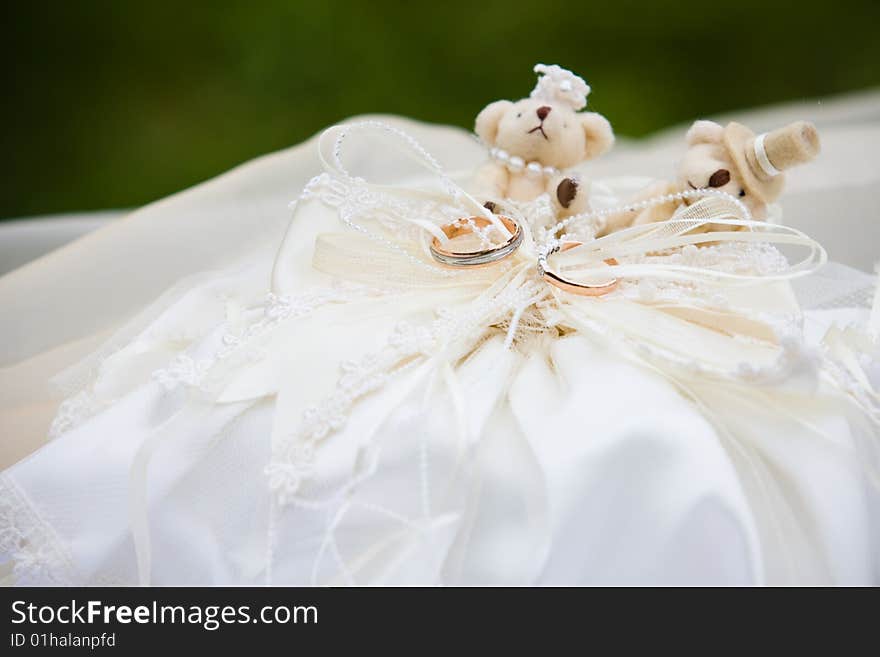 Wedding rings on the ring textile holder with two teddy bears. Wedding rings on the ring textile holder with two teddy bears