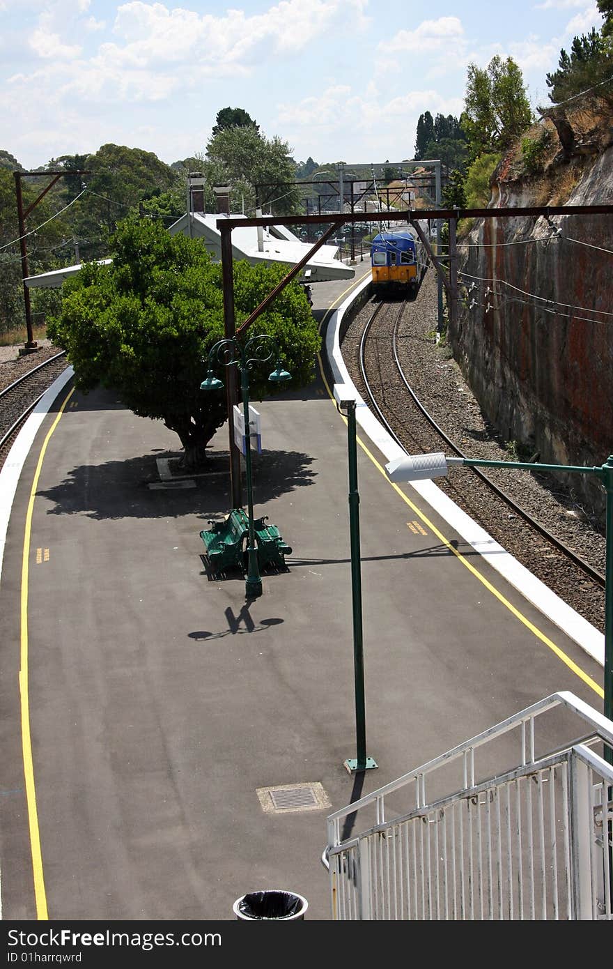 An elevated view of a small rural railway station with an approaching train. An elevated view of a small rural railway station with an approaching train.