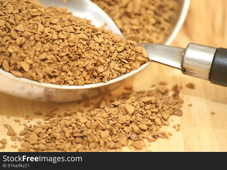 A macro view of coffee granules and a spoon. A macro view of coffee granules and a spoon