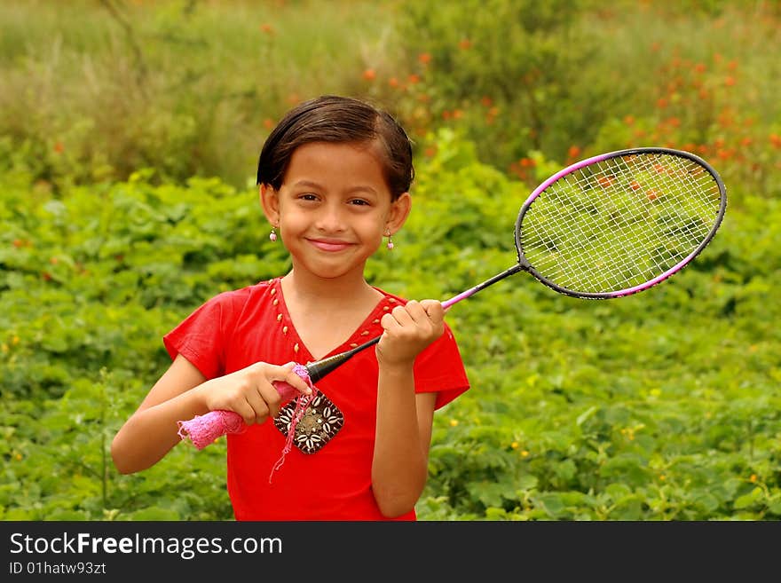 A girl with her badminton bat ready to play. A girl with her badminton bat ready to play.