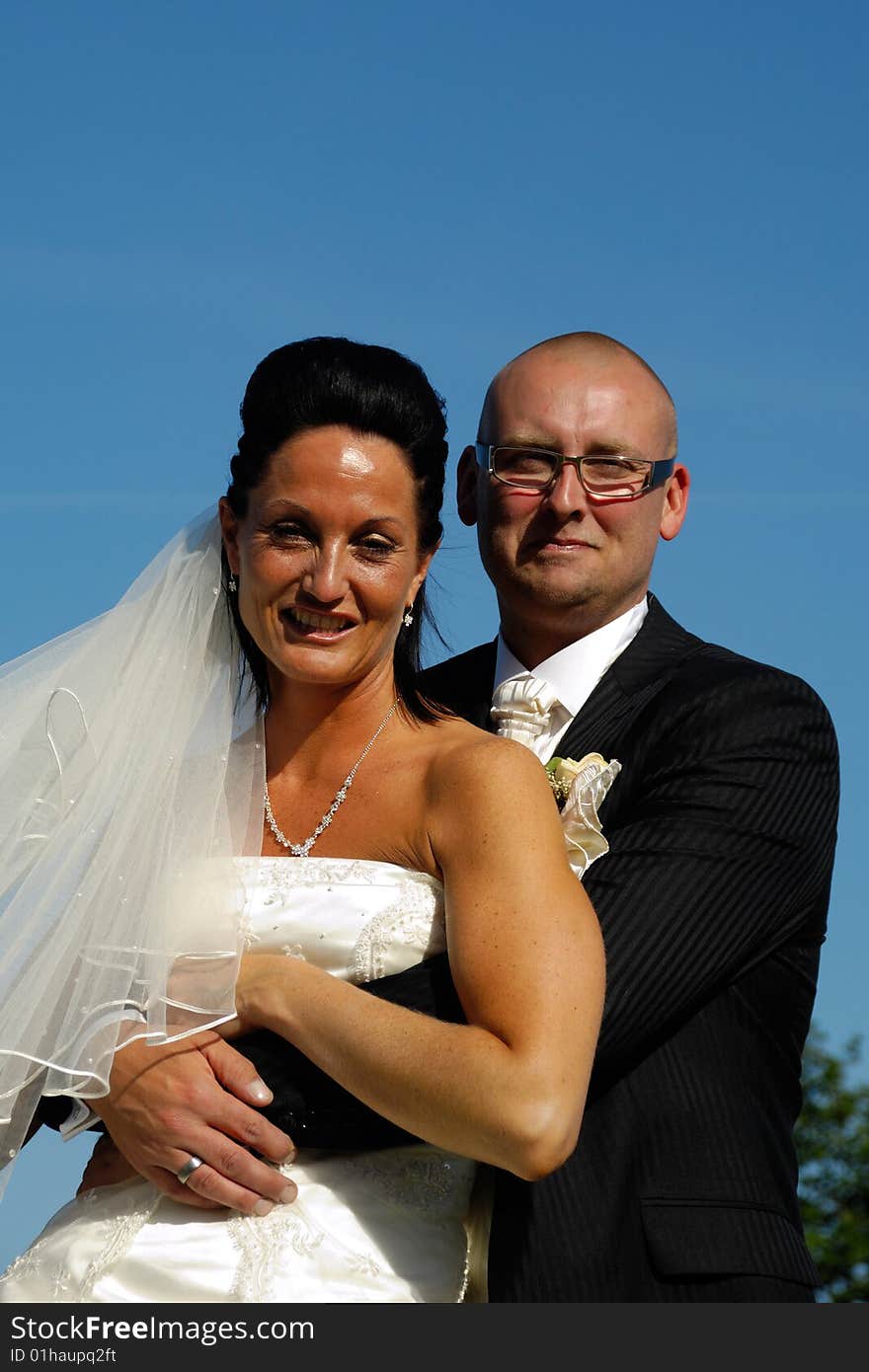 Happy wedding couple togeter. The groom is holding his arms around his bride. Happy wedding couple togeter. The groom is holding his arms around his bride.