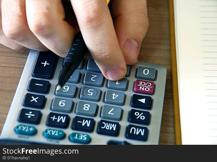 Man fingers over gray calculator buttons closeup. Man fingers over gray calculator buttons closeup