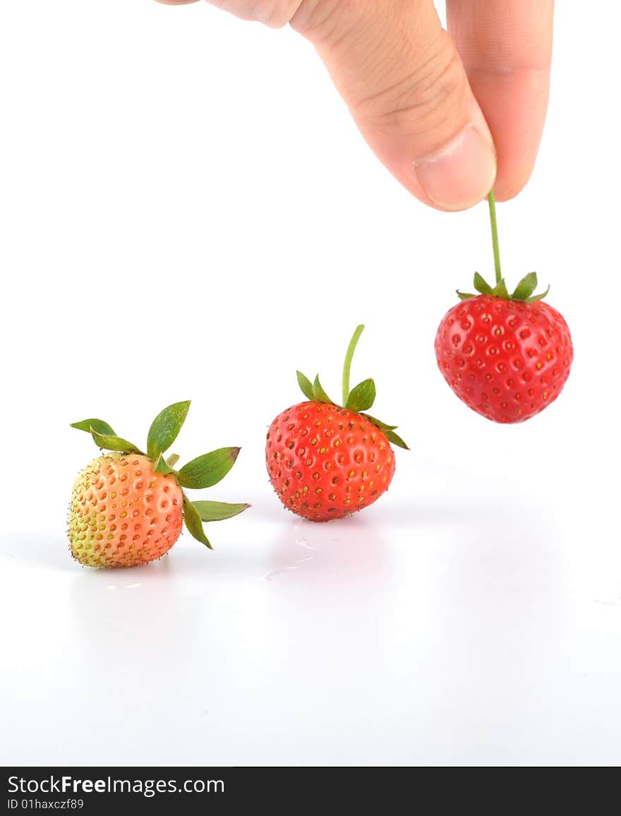 The hand is taking the strawberry. The hand is taking the strawberry