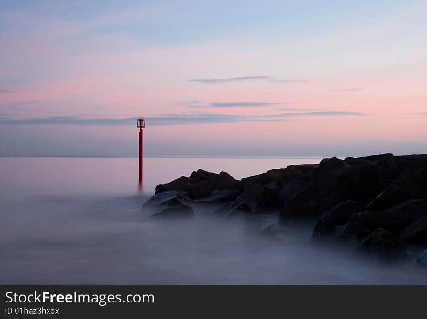 In this photo is buoy near rocks. Was taken in West Bay, Dorset, England.