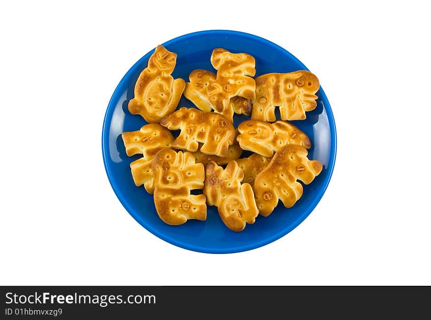 Cookies in the form of animals on a dark blue saucer. White background. Cookies in the form of animals on a dark blue saucer. White background.