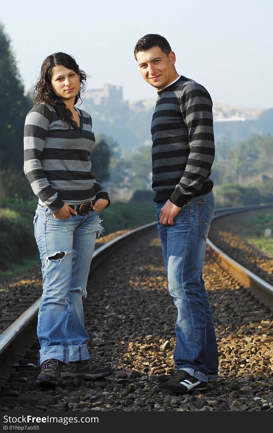 Young couple looking each other on railway tracks. Young couple looking each other on railway tracks