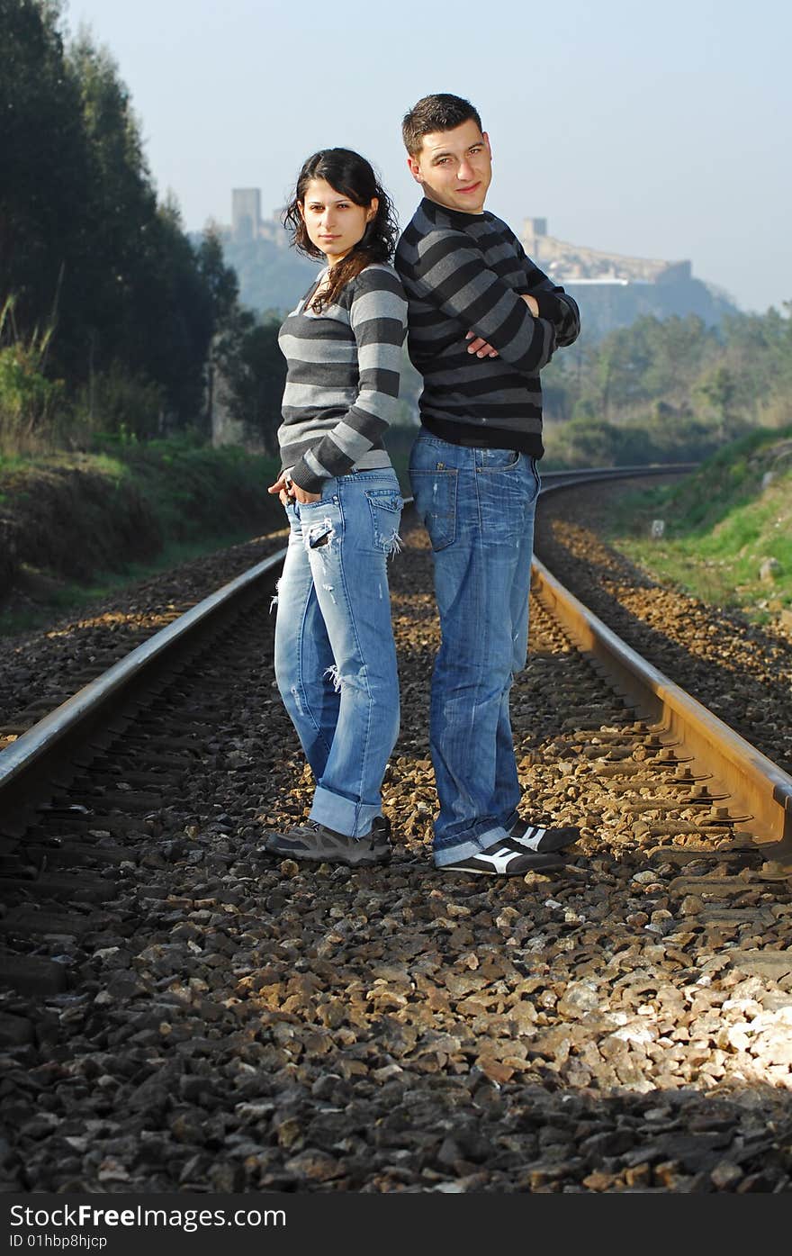 Young couple looking each other on railway tracks. Young couple looking each other on railway tracks