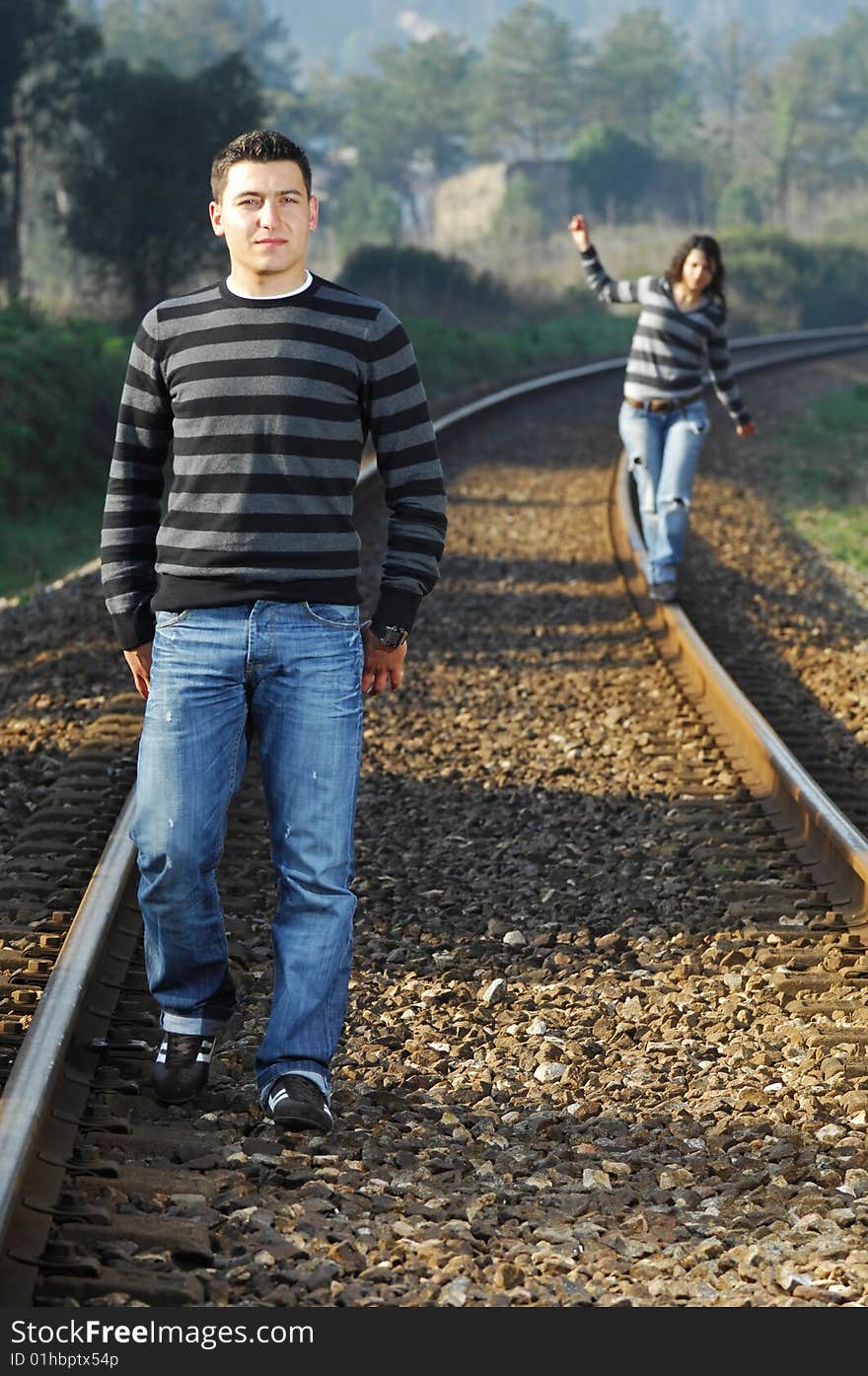 Young couple walking on railway tracks