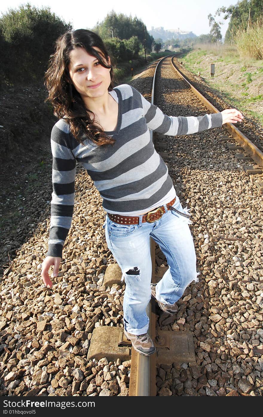 Beautiful girl walking on a railway track