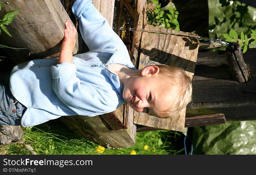 Toddler boy playing outside by an old-fashioned fountain. Toddler boy playing outside by an old-fashioned fountain