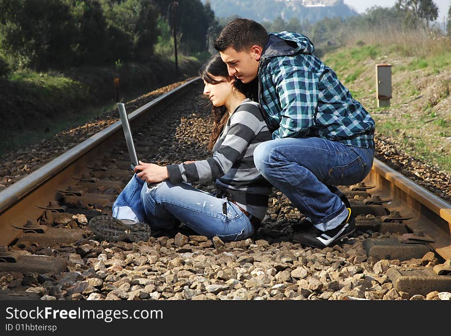 A young couple standing on a railway