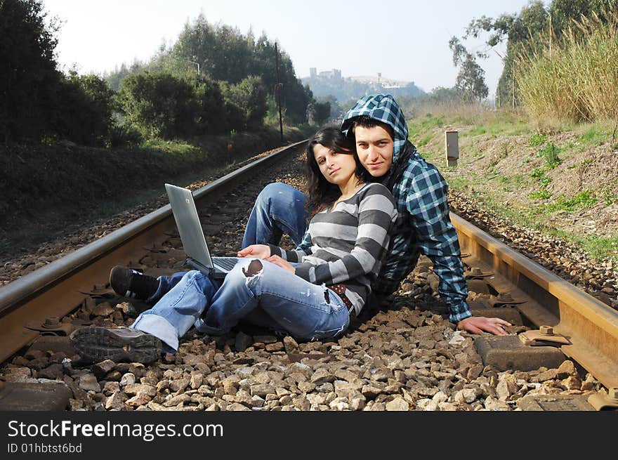 A Young Couple Standing On A Railway