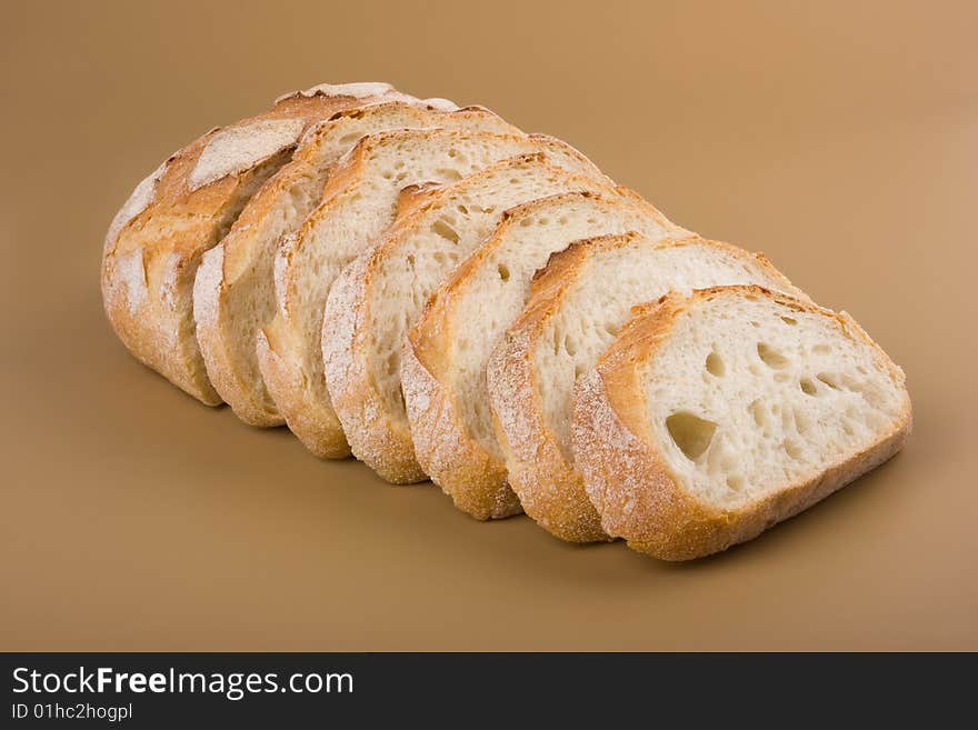 Slices of fresh village bread at the brown background