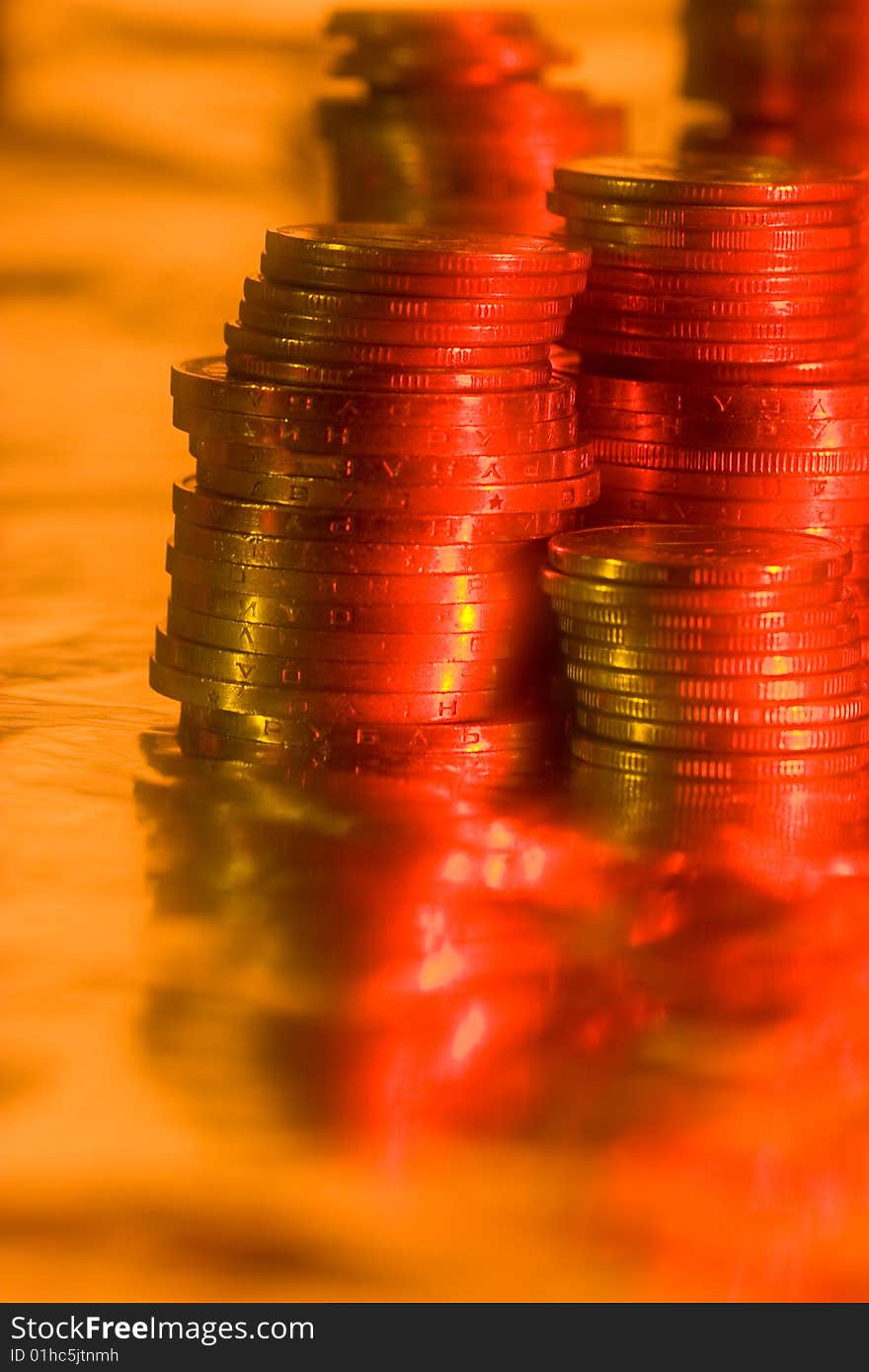 Money series: heap of coins on reflective surface