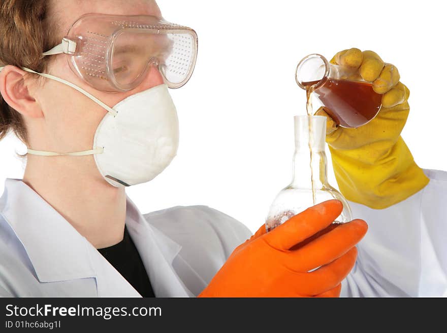 View on scientist in respirator and rubber gloves pours  brown liquid from one flask in another. View on scientist in respirator and rubber gloves pours  brown liquid from one flask in another