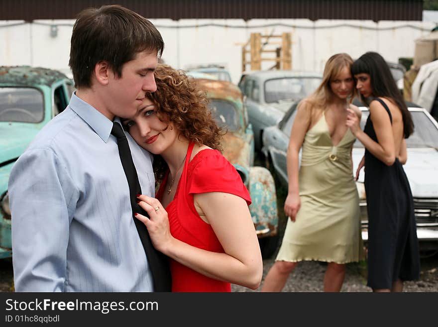 Love and jealousy - couple and two girl beside vintage cars