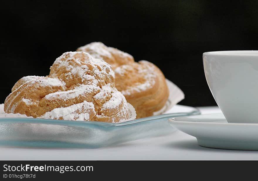 Pastries on a glass plate and white cup. Pastries on a glass plate and white cup