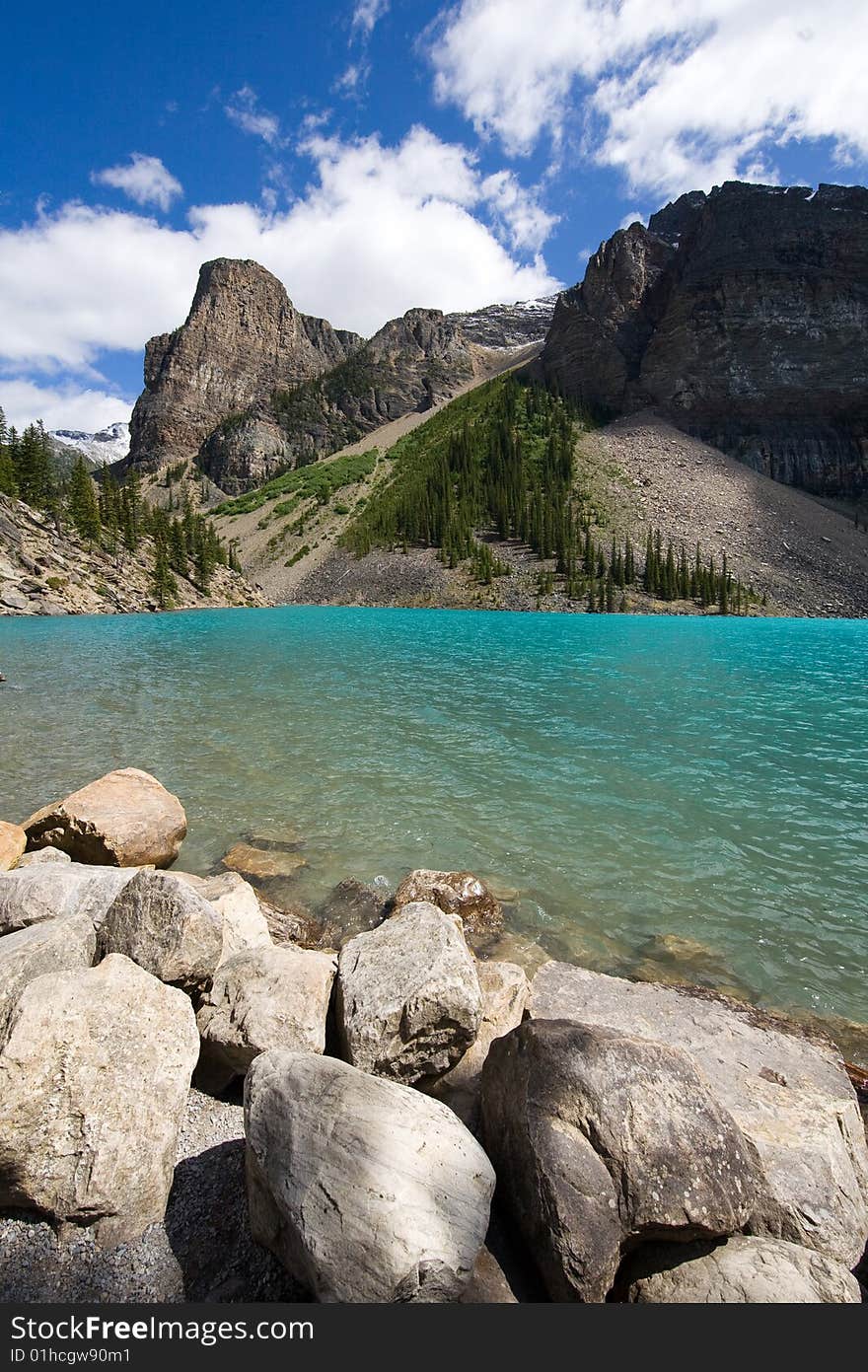 Lake Moraine framed with the rocks in the foreground and the distant mountains