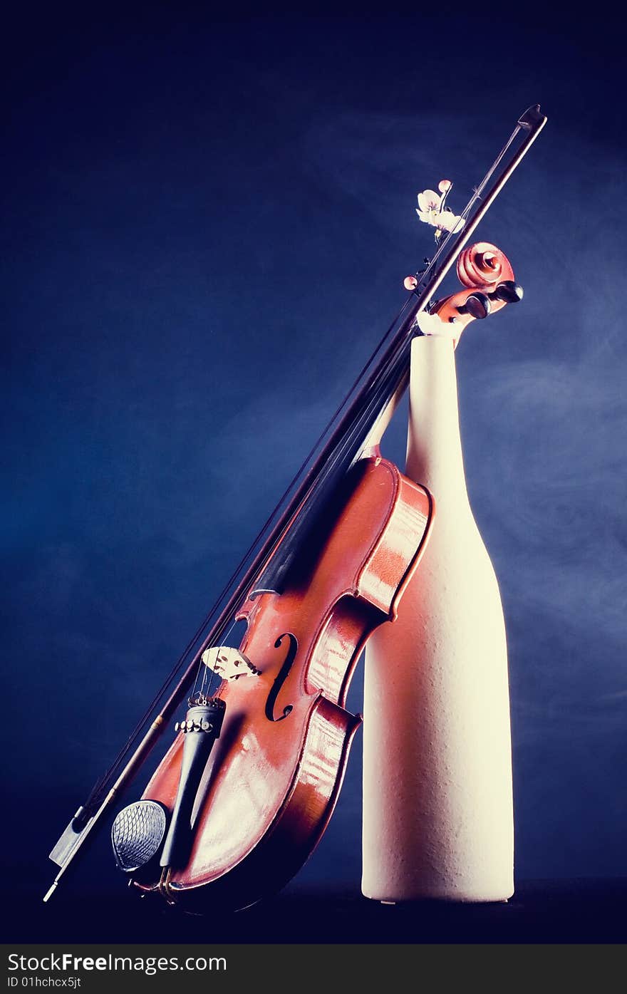 Violin details with terracotta vase and flower