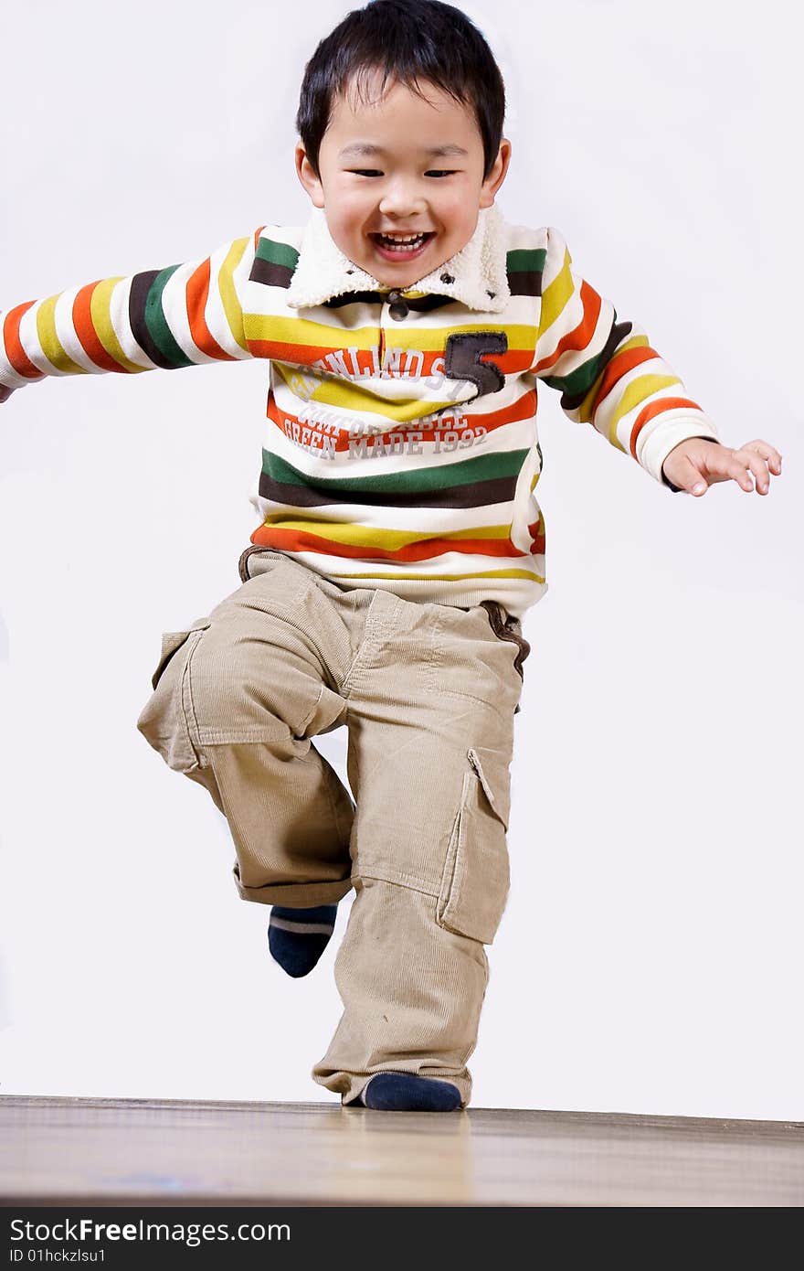 A picture of a little chinese boy jumping, laughing and having great fun himself. A picture of a little chinese boy jumping, laughing and having great fun himself