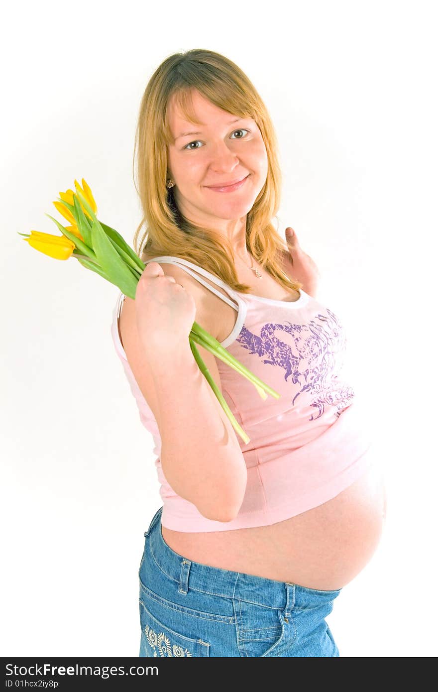 Young pregnant woman with yellow tulips on white. Young pregnant woman with yellow tulips on white