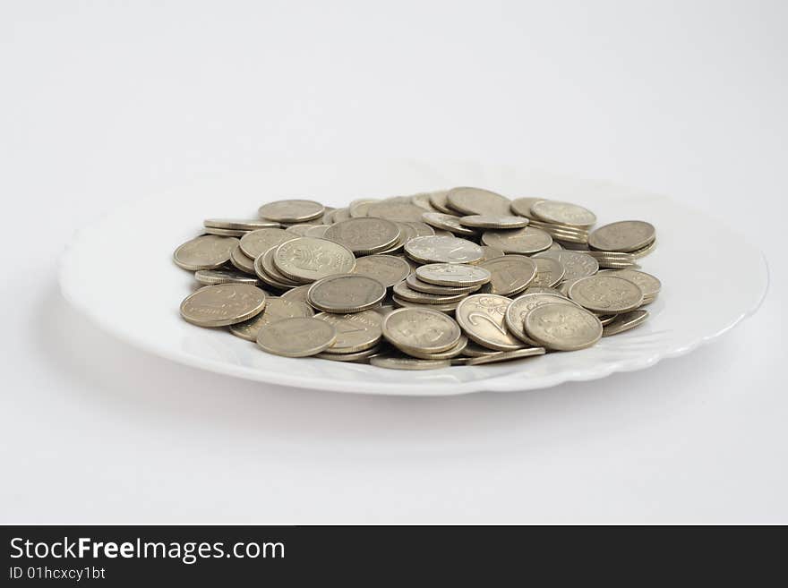 Plate with coins isolated on white background