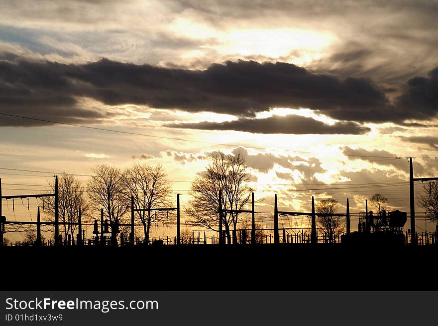 Dramatic sunset over electric substation silhouette