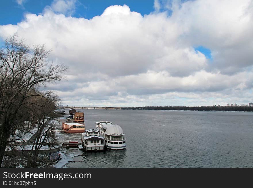 Berth on spring Dnieper river  in Kiev, Ukraine under dramatic cloudy sky. Berth on spring Dnieper river  in Kiev, Ukraine under dramatic cloudy sky