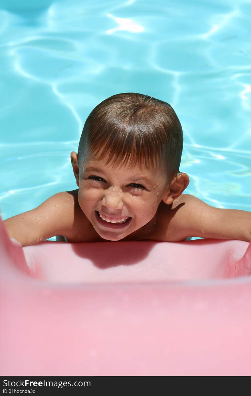 Boy smiling on a smimming pool slide