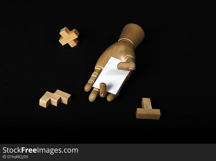 Wooden hand holding a card near wooden blocks. Wooden hand holding a card near wooden blocks