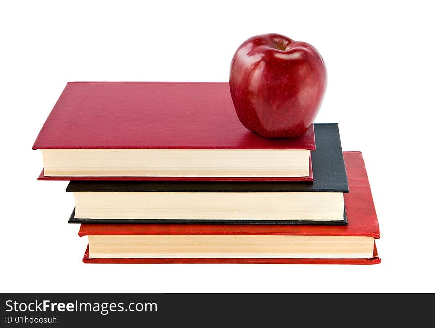 A red apple on a stack of books. A red apple on a stack of books