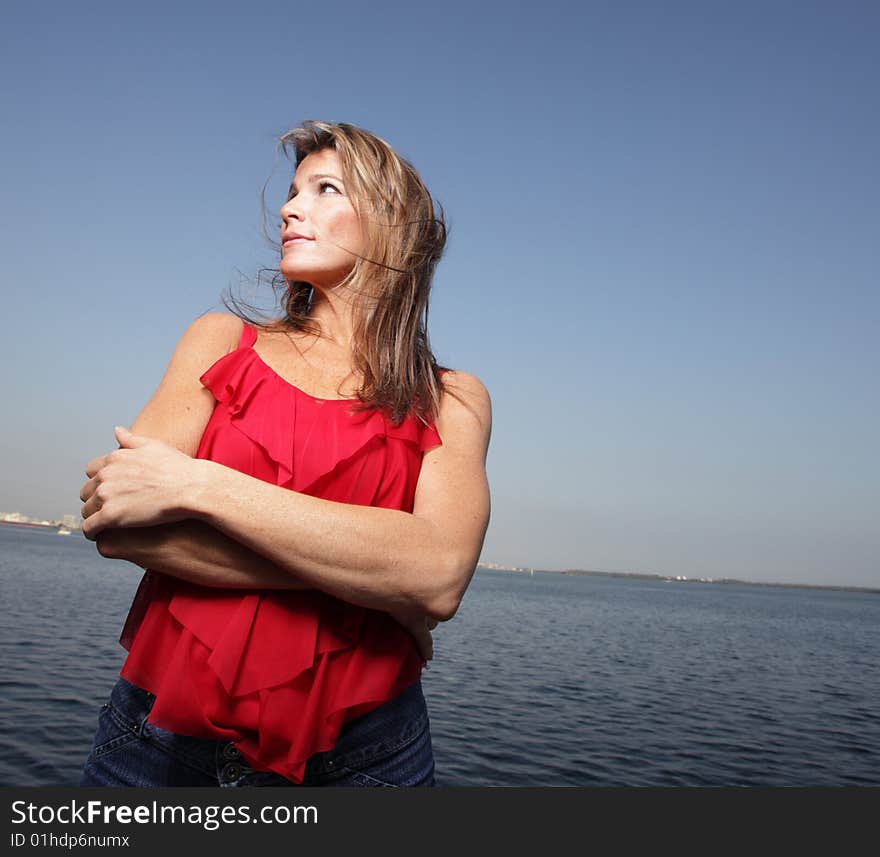 Woman wearing a red shirt with a blue horizon in the background. Woman wearing a red shirt with a blue horizon in the background