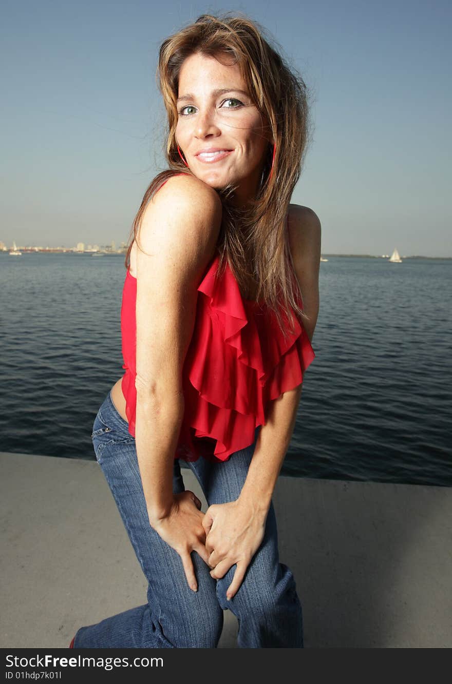 Woman wearing a red shirt with a blue horizon in the background. Woman wearing a red shirt with a blue horizon in the background