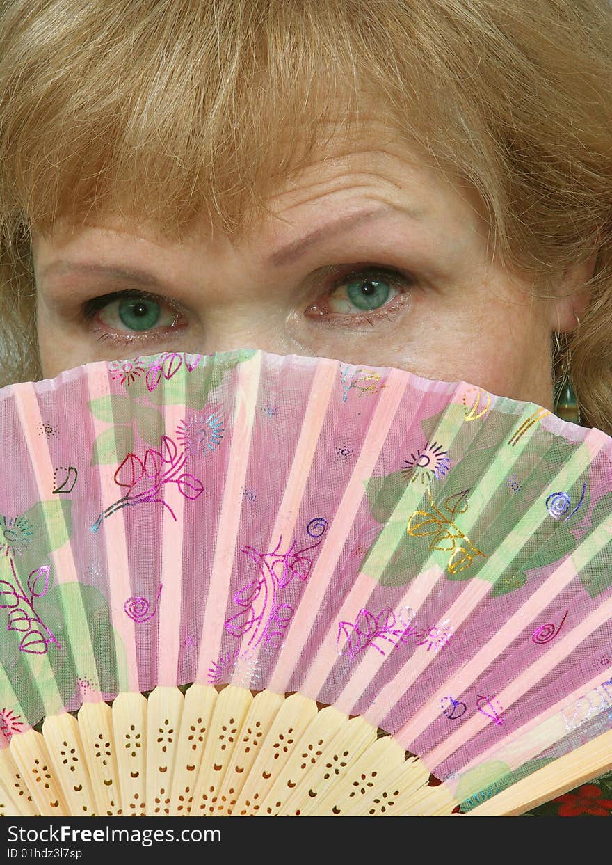 Woman face with green eyes is closed fan. Woman face with green eyes is closed fan