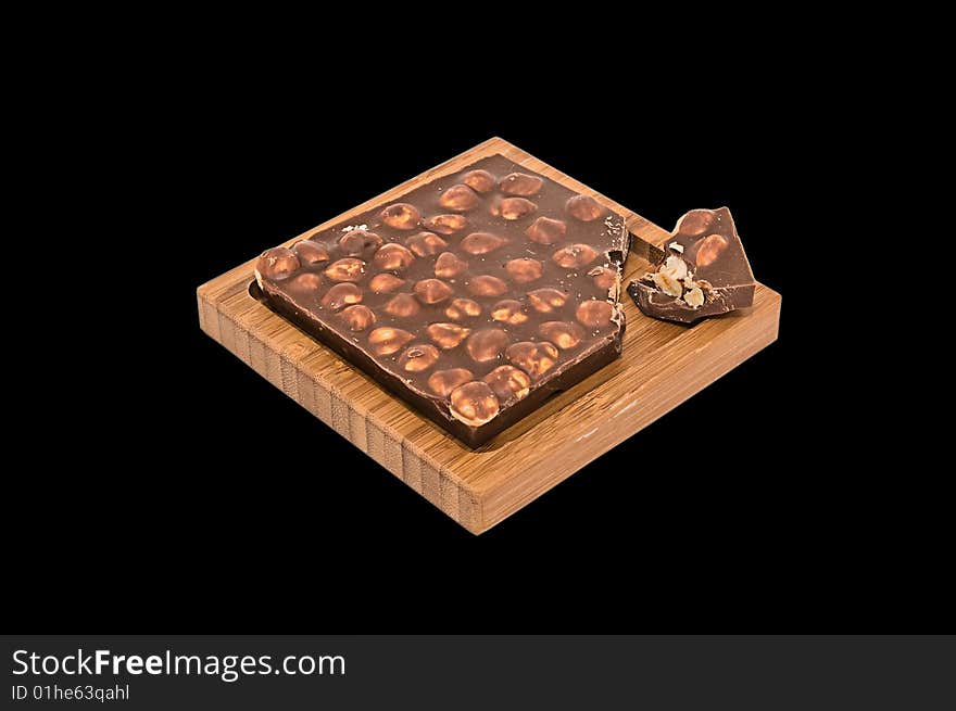 The hazelnut chocolate wooden plate on a black background